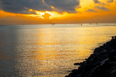 Sakin şafak deniz manzarası. Denizin üzerinde güzel bir gün doğumu, geleneksel balıkçı teknelerinin ilk ışığa yetişmesi..