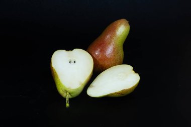 Kesilmiş ve armut üstüne armut, sulu derilerini ve canlı derilerini renklendiriyor. Yemek fotoğrafçılığı, diyet ve taze meyve görselleri için ideal..