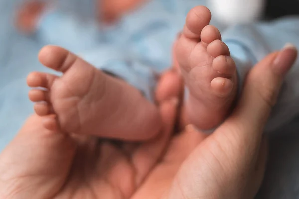 Κοντινό Πλάνο Χέρια Της Μητέρας Κρατούν Μικροσκοπικά Πόδια Του Νεογέννητου — Φωτογραφία Αρχείου