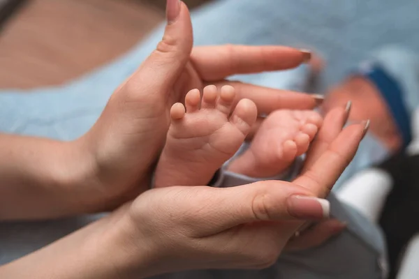 Παλάμες Της Μητέρας Κρατούν Πόδι Του Νεογέννητου Μωρού Μπλε Κουβέρτα — Φωτογραφία Αρχείου