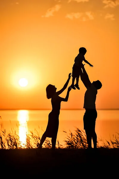 Silhouettes of Happy family. Evening light. Love and family. Father\'s Day background.