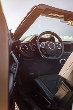 Üstü açılabilen, siyah deri koltuklar, modern direksiyon, ve göstergeli ve düğmeli ayrıntılı gösterge paneli. Gündüz vakti, insan yok. Otomotiv ve seyahat reklamları için ideal.
