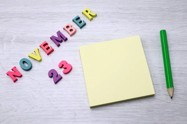 11月23日 木のテーブルの背景にブロックノートと鉛筆で毎日カラフルなカレンダー あなたのテキストやデザインのための空のスペース — ストック写真