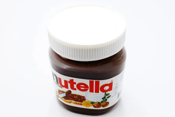 坚果与费雷罗生产的可可一起散布在Nutella罐中 — 图库照片