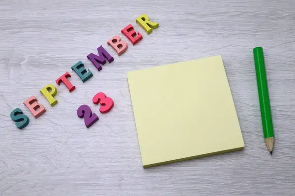 9月23日 木のテーブルの背景にブロックノートと鉛筆で毎日カラフルなカレンダー あなたのテキストやデザインのための空のスペース — ストック写真