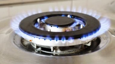 Gaz ocağı ve yanan gaz alevleri. Mavi alevleri yanan ev mutfağı