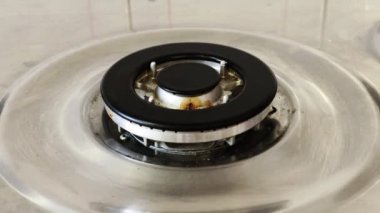 Gaz ocağı ve yanan gaz alevleri. Mavi alevleri yanan ev mutfağı