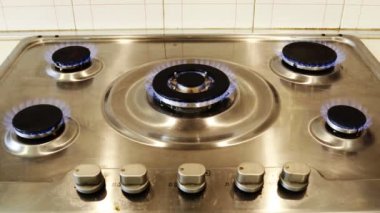 Gaz ocağı ve yanan gaz alevleri. Mavi alevleri yanan ev mutfağı