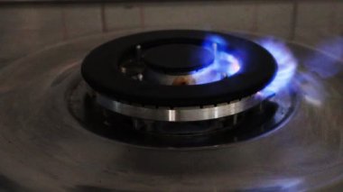 Gaz ocağı ve yanan gaz alevleri. Mavi alevleri yanan ev mutfağı