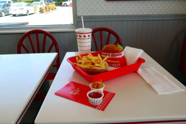 Los Angeles, Kaliforniya 23 Haziran 2023 IN-N-Out Burger, Double-Double Burger ve patates kızartması fast-food restoranının içindeki masada bir tepside.