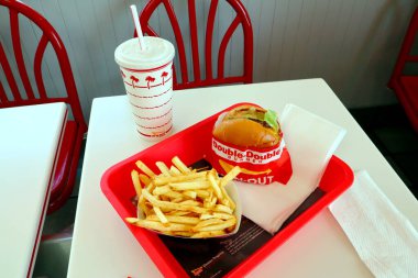 Los Angeles, Kaliforniya 23 Haziran 2023 IN-N-Out Burger, Double-Double Burger ve patates kızartması fast-food restoranının içindeki masada bir tepside.
