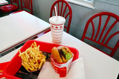 Los Angeles, Kaliforniya 23 Haziran 2023 IN-N-Out Burger, Double-Double Burger ve patates kızartması fast-food restoranının içindeki masada bir tepside.