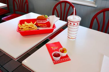 Los Angeles, Kaliforniya 23 Haziran 2023 IN-N-Out Burger, Double-Double Burger ve patates kızartması fast-food restoranının içindeki masada bir tepside.