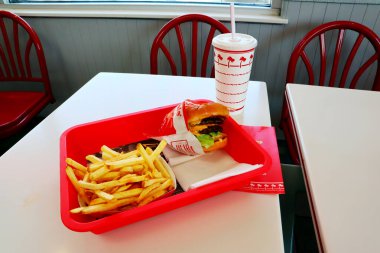 Los Angeles, Kaliforniya 23 Haziran 2023 IN-N-Out Burger, Double-Double Burger ve patates kızartması fast-food restoranının içindeki masada bir tepside.