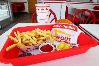 Los Angeles, California - 5 Mayıs 2024 Fast food restoranının içindeki masada yedikten sonra In-N Out Double Burger ve patates kızartması