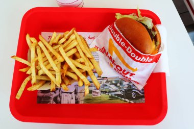 Los Angeles, California - 5 Mayıs 2024 Fast food restoranının içindeki masada yedikten sonra In-N Out Double Burger ve patates kızartması