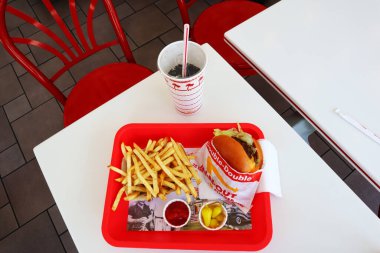 Los Angeles, California - 5 Mayıs 2024 Fast food restoranının içindeki masada yedikten sonra In-N Out Double Burger ve patates kızartması