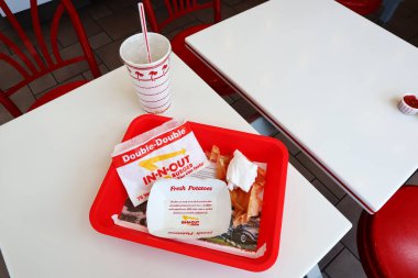Los Angeles, California - 5 Mayıs 2024 Fast food restoranının içindeki masada yedikten sonra In-N Out Double Burger ve patates kızartması