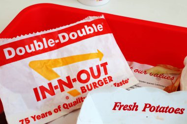 Los Angeles, California - 5 Mayıs 2024 Fast food restoranının içindeki masada yedikten sonra In-N Out Double Burger ve patates kızartması