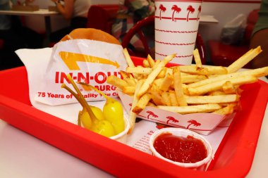 Los Angeles, California - 23 Mayıs 2024: In-N-Out Burger, Hamburger ve patates kızartması fast-food restoranının içindeki masada bir tepside