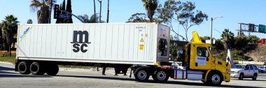 Los Angeles, California - 13 January 2025: Freight Truck carrying a MSC Mediterranean Shipping Co. shipping container on a street toward the Port of Los Angeles in San Pedro clipart