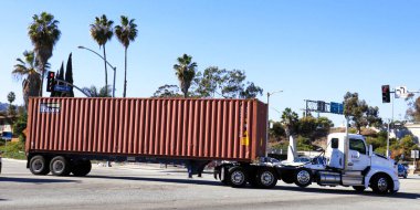 Los Angeles, California - 13 January 2025: Freight Truck carrying a FLORENS shipping container on a street toward the Port of Los Angeles in San Pedro clipart