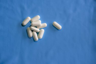 Mavi arka planda beyaz haplar