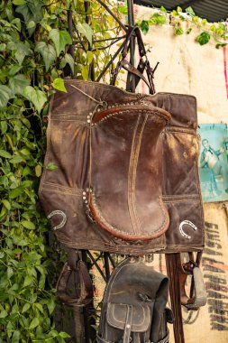 Eski duvarda eski deri çanta ve çanta var.