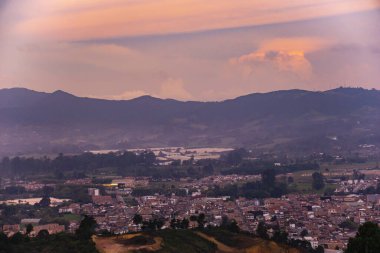 Dağları ve bulutlu gökyüzü olan güzel bir manzara.