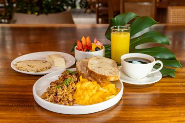 Arepas, kahve, ekmek, yumurta, pirinç ve meyveli Kolombiya kahvaltısı.