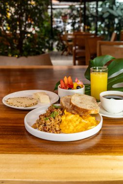 Arepas, kahve, ekmek, yumurta, pirinç ve meyveli Kolombiya kahvaltısı.
