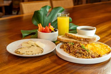 Arepas, kahve, ekmek, yumurta, pirinç ve meyveli Kolombiya kahvaltısı.