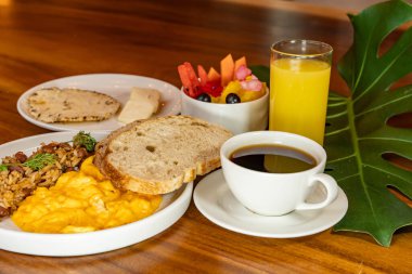 Arepas, kahve, ekmek, yumurta, pirinç ve meyveli Kolombiya kahvaltısı.