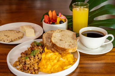 Arepas, kahve, ekmek, yumurta, pirinç ve meyveli Kolombiya kahvaltısı.