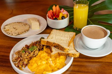 Arepas, kahve, ekmek, yumurta, pirinç ve meyveli Kolombiya kahvaltısı.