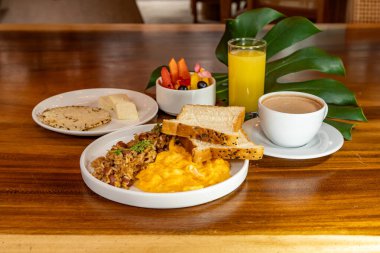 Arepas, kahve, ekmek, yumurta, pirinç ve meyveli Kolombiya kahvaltısı.