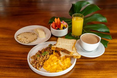 Arepas, kahve, ekmek, yumurta, pirinç ve meyveli Kolombiya kahvaltısı.