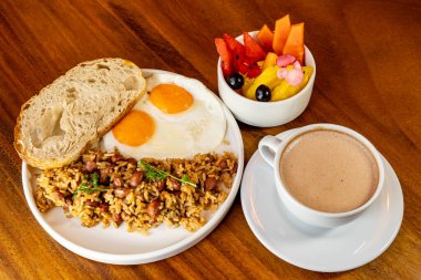 Arepas, kahve, ekmek, yumurta, pirinç ve meyveli Kolombiya kahvaltısı.