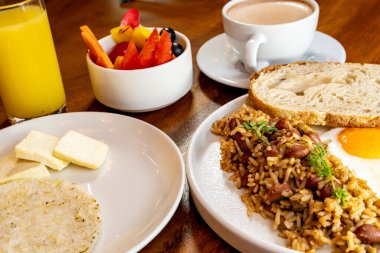Arepas, kahve, ekmek, yumurta, pirinç ve meyveli Kolombiya kahvaltısı.