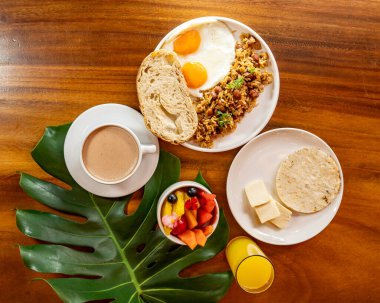 Arepas, kahve, ekmek, yumurta, pirinç ve meyveli Kolombiya kahvaltısı.