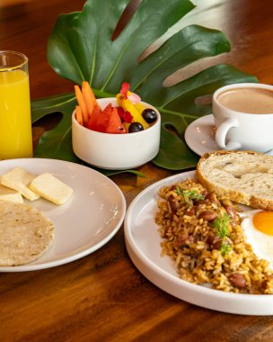 Arepas, kahve, ekmek, yumurta, pirinç ve meyveli Kolombiya kahvaltısı.