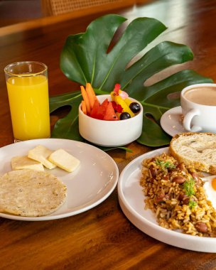 Arepas, kahve, ekmek, yumurta, pirinç ve meyveli Kolombiya kahvaltısı.