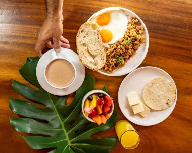 Arepas, kahve, ekmek, yumurta, pirinç ve meyveli Kolombiya kahvaltısı.