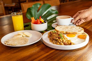 Arepas, kahve, ekmek, yumurta, pirinç ve meyveli Kolombiya kahvaltısı.