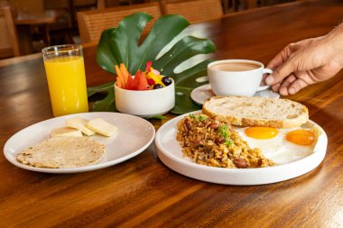 Arepas, kahve, ekmek, yumurta, pirinç ve meyveli Kolombiya kahvaltısı.