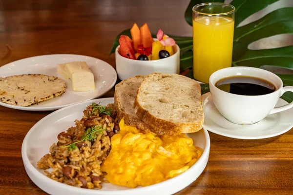 Arepas, kahve, ekmek, yumurta, pirinç ve meyveli Kolombiya kahvaltısı.