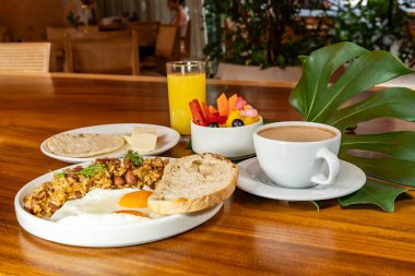Arepas, kahve, ekmek, yumurta, pirinç ve meyveli Kolombiya kahvaltısı.