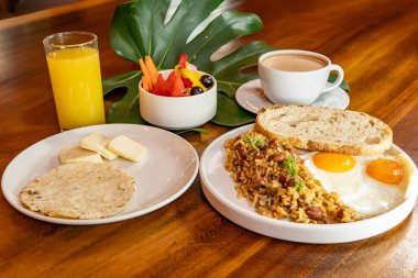 Arepas, kahve, ekmek, yumurta, pirinç ve meyveli Kolombiya kahvaltısı.