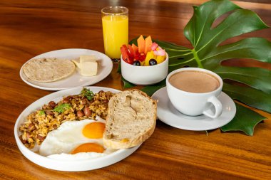 Arepas, kahve, ekmek, yumurta, pirinç ve meyveli Kolombiya kahvaltısı.