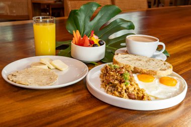 Arepas, kahve, ekmek, yumurta, pirinç ve meyveli Kolombiya kahvaltısı.